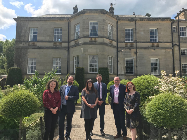 Group of people stood outside a manor house