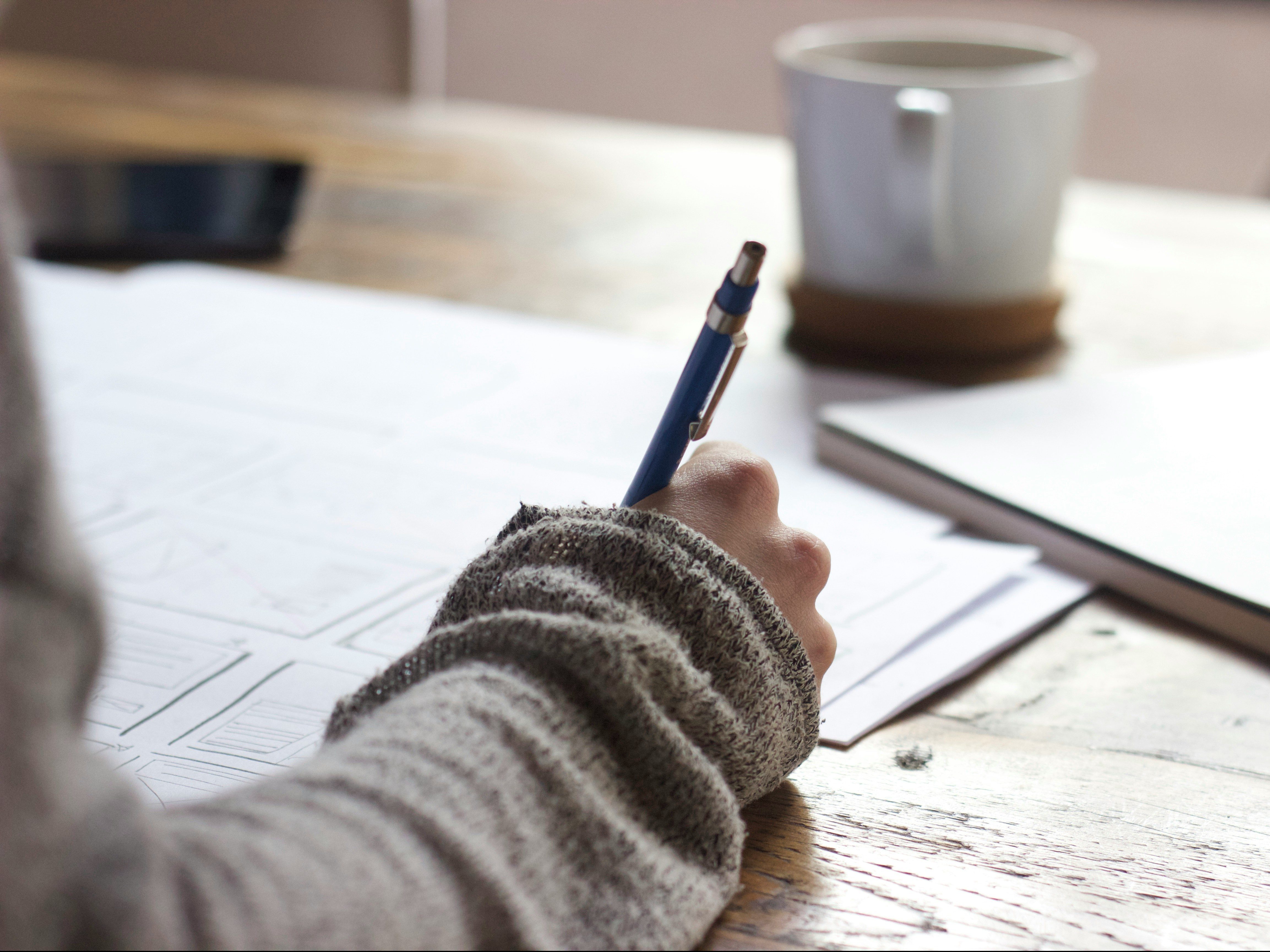 person writing at a desk