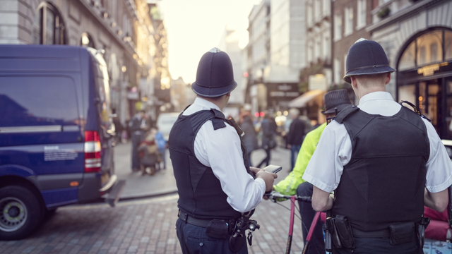 Police officers on street talking to cyclist