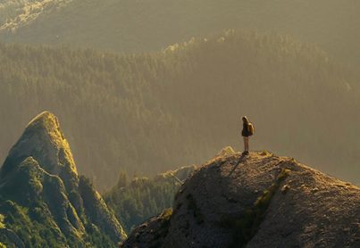 A hill climber at the top of a peak