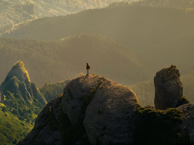 A hill climber at the top of a peak