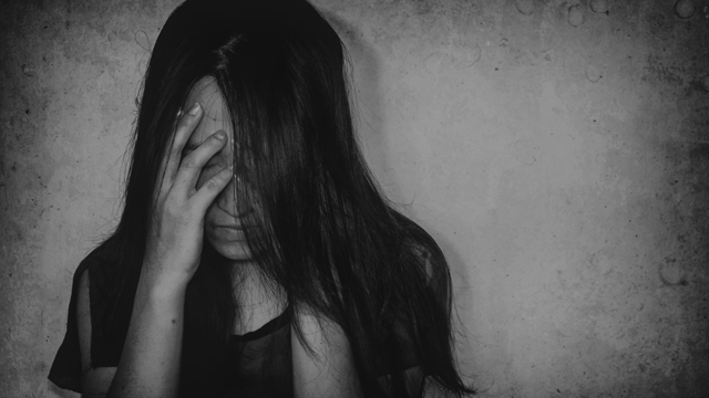 Depressed girl with head in hands