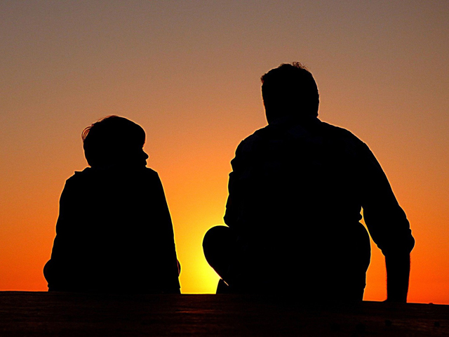 Sunset silhouette of man and boy