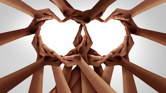 Many hands interlinked to form two heart shapes