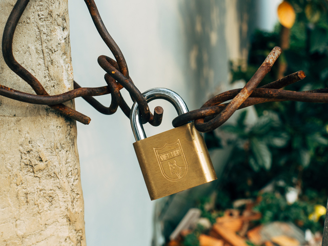 A padlock attached to a chain link fence