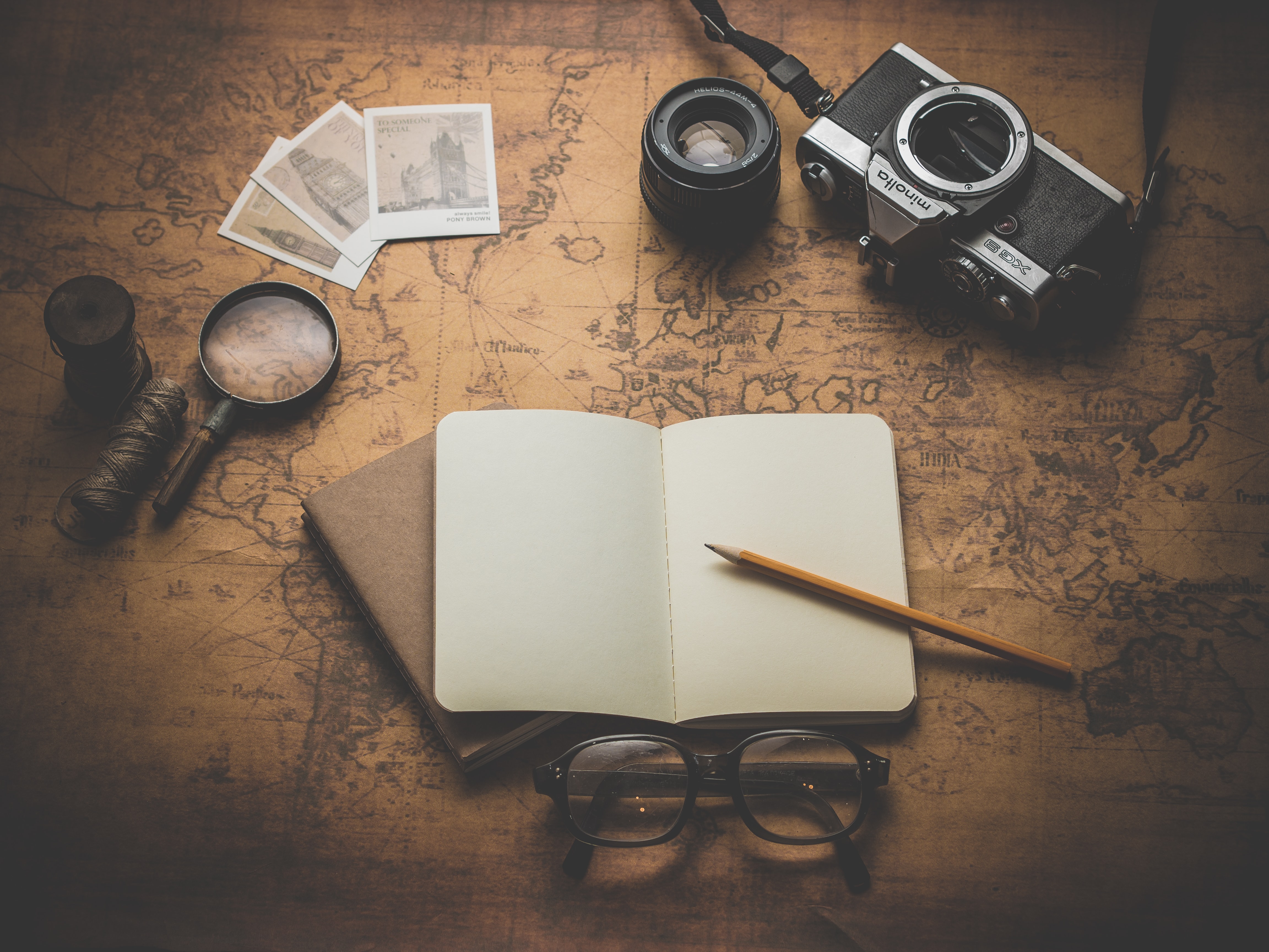 empty notebook, camera, map, magnifying glass