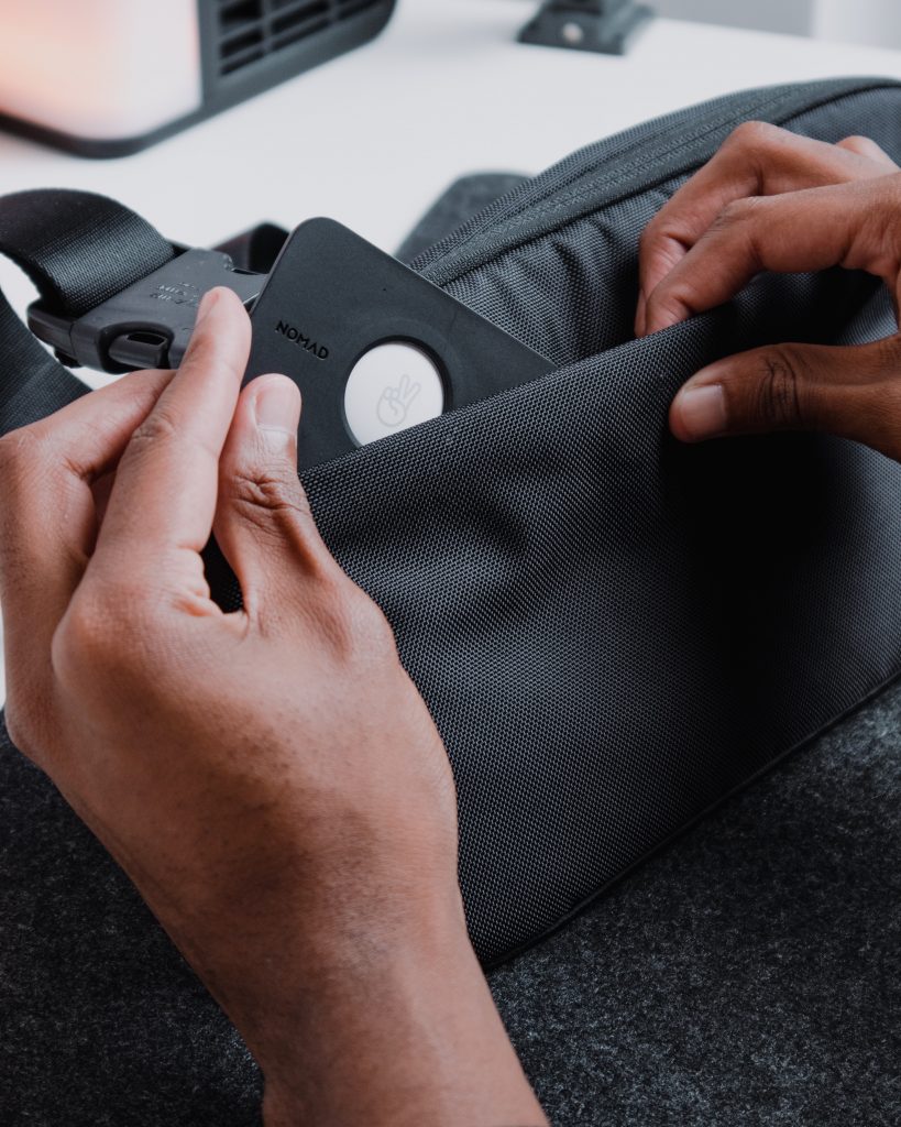 Close up of hands putting a technological device into a bag