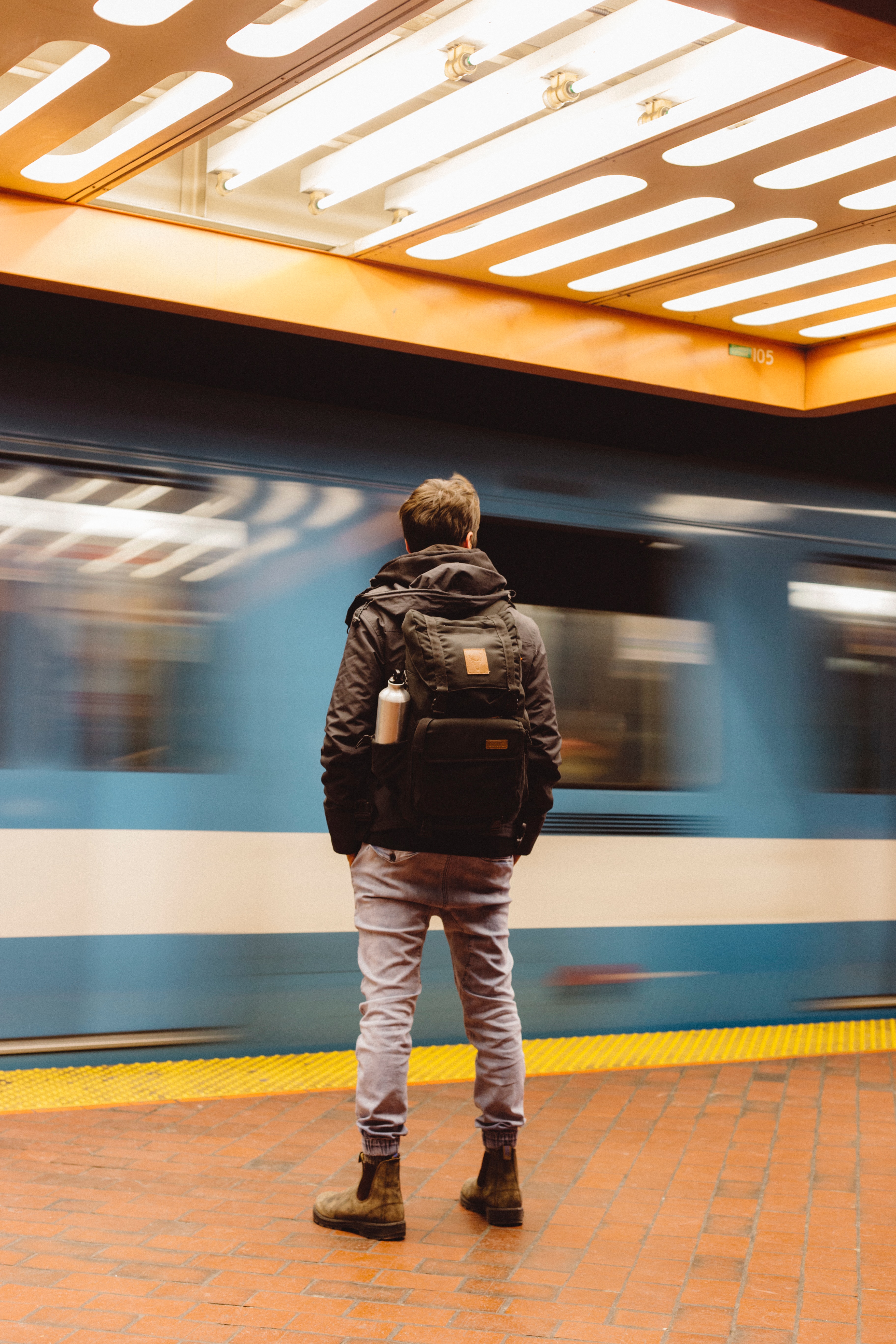 man on a train platform as a train goes past