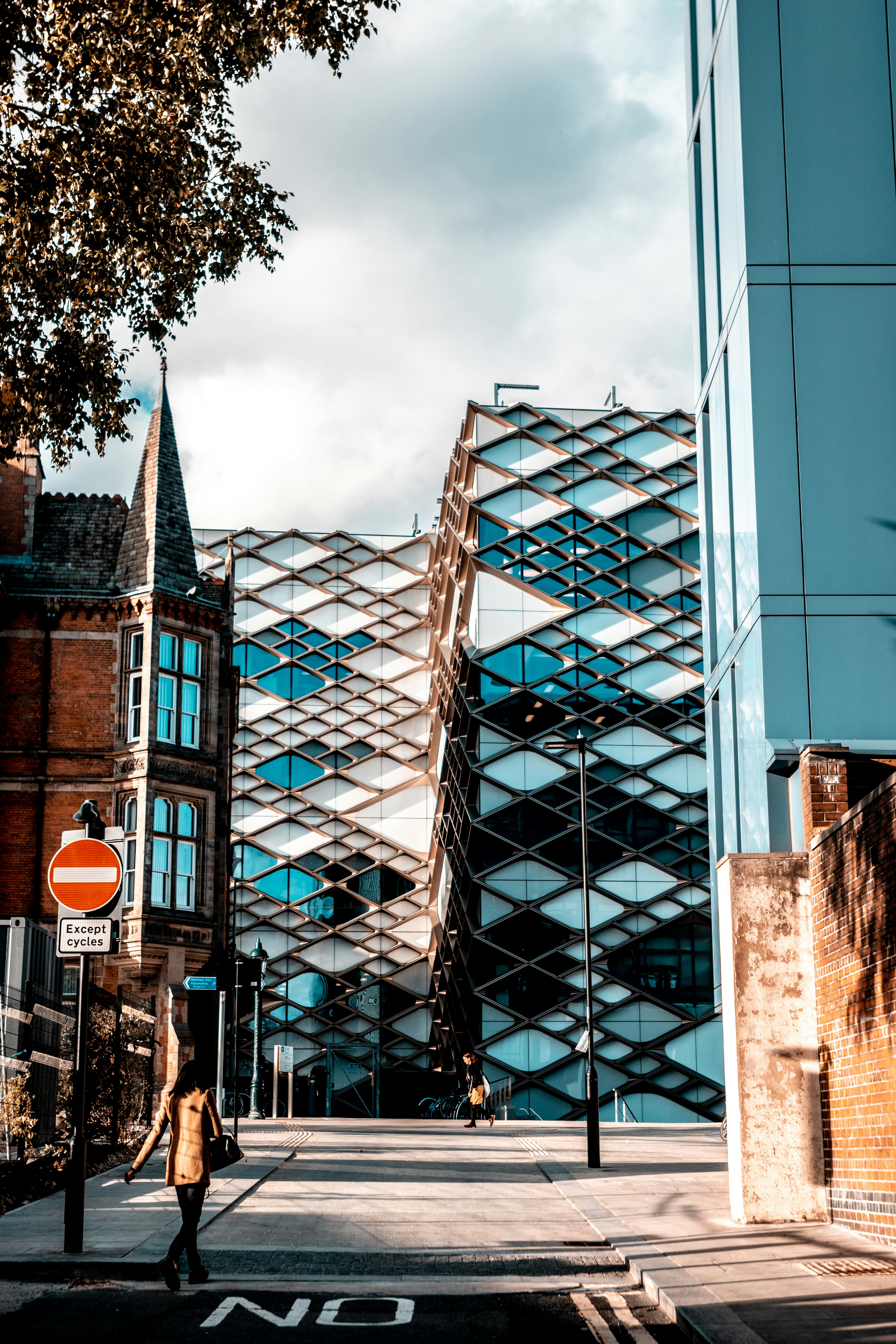 Glass and concrete building seen between brick buildings