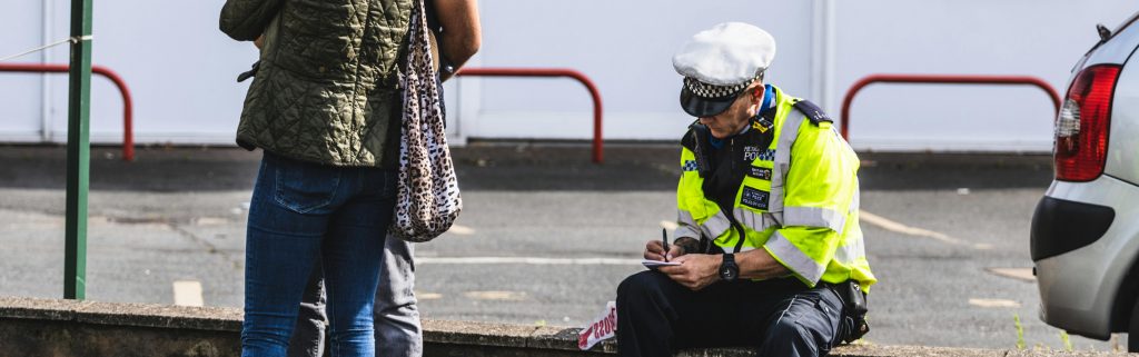 Police Office Sitting on Wall and Writing