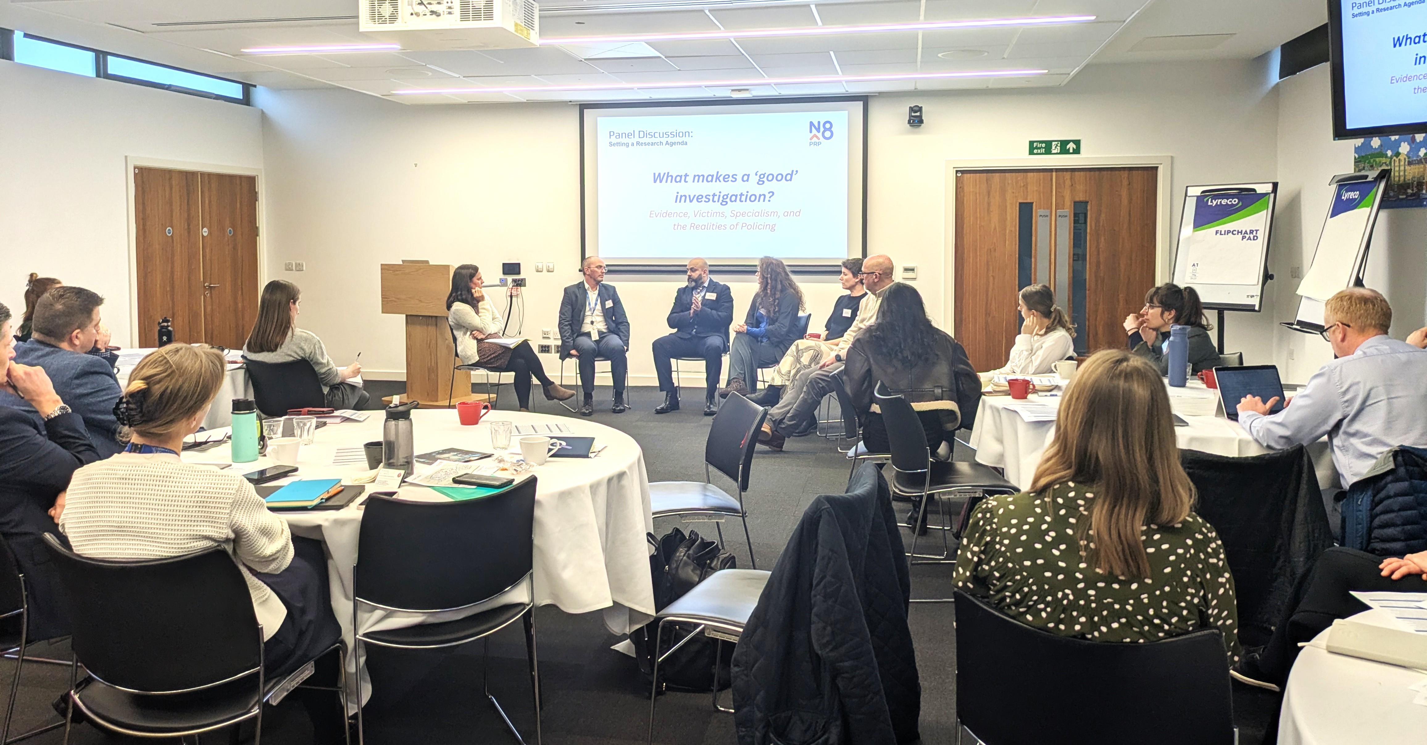 6 people sit in a semi circle in front of a conference room