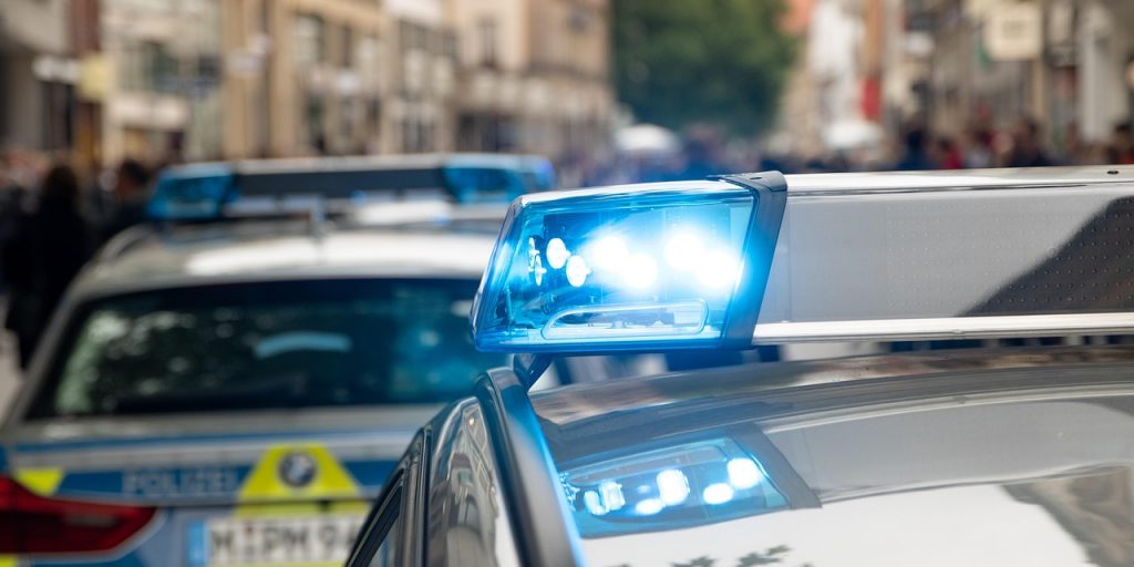 Close up of blue light on a police car with another police car in the background.