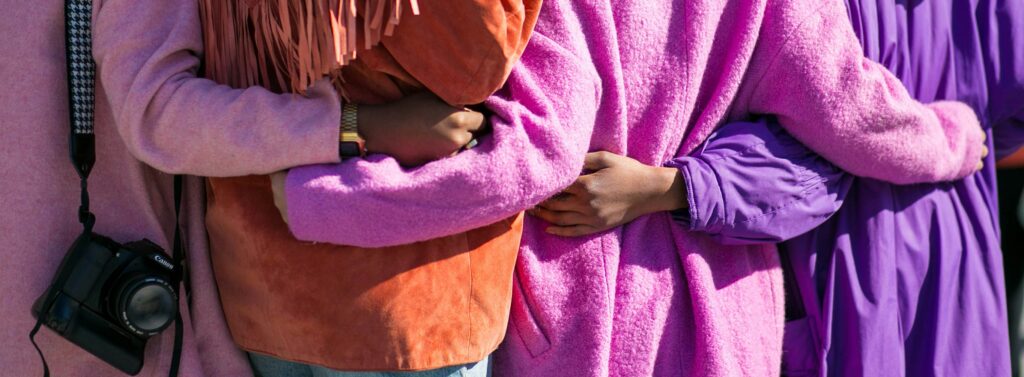 four women holding each others waist